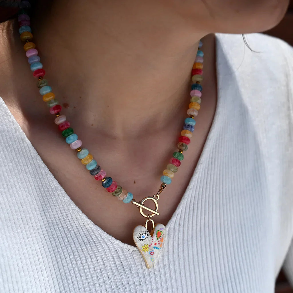 Collar de cuentas de piedras preciosas multicolor con colgante de corazón pintado.
